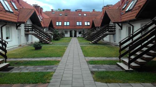 a row of houses with red roofs and a pathway at Apartament w Giżycku przy plaży in Giżycko