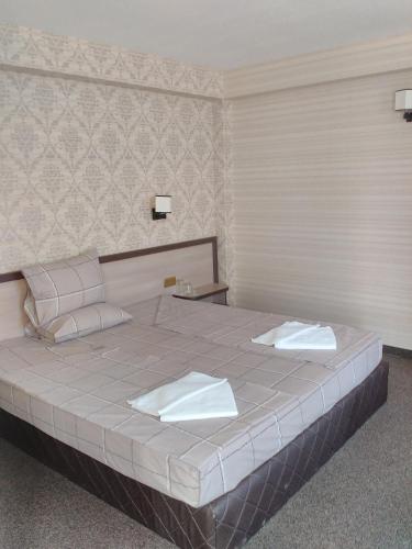 a bedroom with a large bed with two towels on it at Casa Blanca in Sofia