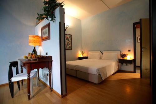 a bedroom with a bed and a table with a lamp at L'Angolo Di Beppe in Torre Lapillo