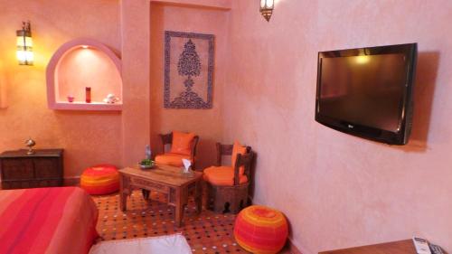 ein Wohnzimmer mit einem TV an der Wand in der Unterkunft Riad Dar Zouhour in Rabat