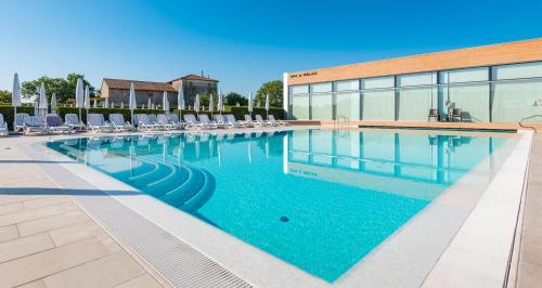 a swimming pool with chairs and a building at Hotel Viest in Vicenza