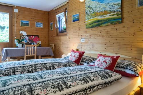 two beds in a room with wooden walls at B&B Gottardo in Airolo