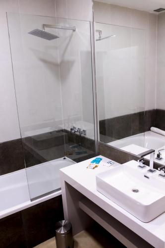 a bathroom with a white sink and a shower at Hostería Atahualpa Yupanqui in Tafí Viejo