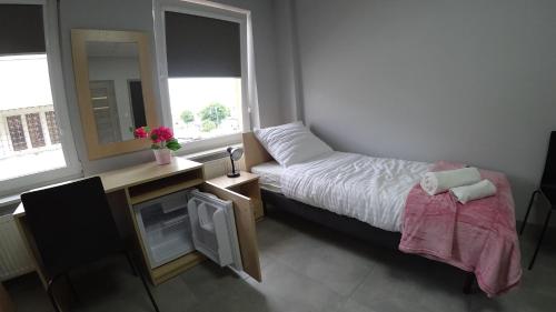 a bedroom with a bed and a desk with a mirror at Apartamenty Kozienice in Kozienice