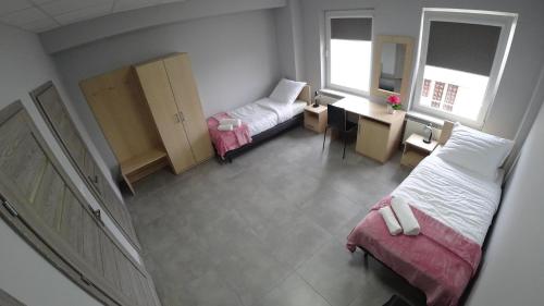 a small room with two beds and a desk at Apartamenty Kozienice in Kozienice