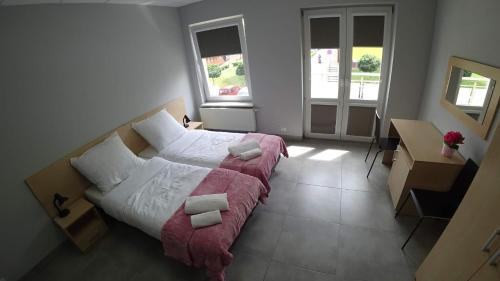 a bedroom with a bed with a red blanket at Apartamenty Kozienice in Kozienice