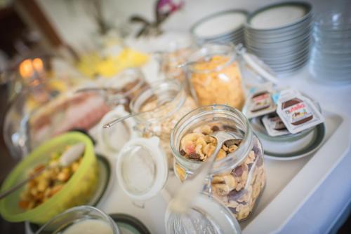 a table topped with jars of food and plates of food at Pension Apartments Pardell in Castelbello-ciardes