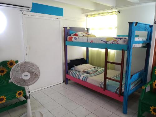 a room with two bunk beds and a fan at Blue Almond Hostel - San Andres in San Andrés