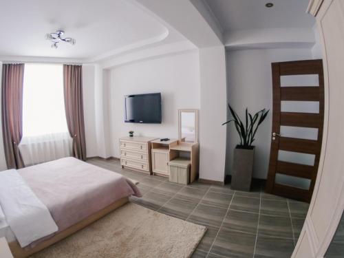 a bedroom with a bed and a dresser and a television at 1 Bedroom Flat near Shopping Malldova! in Chişinău