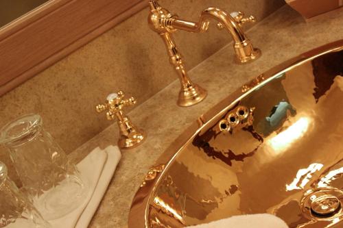 a bathroom sink with gold fixtures on a counter at Château De Riell in Molitg les Bains