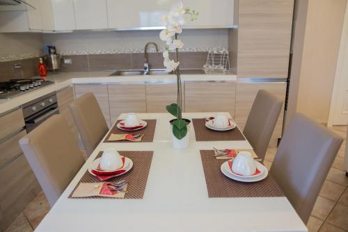 a kitchen with a table with plates and a vase with flowers at Villa Erasi in Fiumicino