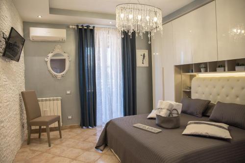 フィウミチーノにあるVilla Erasiのベッドルーム1室(ベッド1台、シャンデリア付)