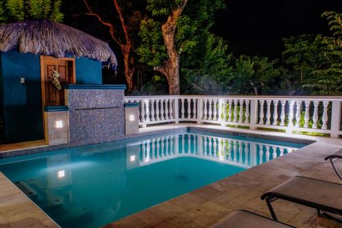 a swimming pool in a backyard at night at Seaside Inn Roatan in West Bay