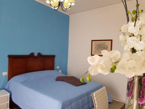 een slaapkamer met een bed en een vaas met witte bloemen bij Tenuta Le Fornacelle in Torre del Greco