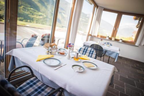 a table in a restaurant with a white table cloth at Pension Apartments Pardell in Castelbello-ciardes