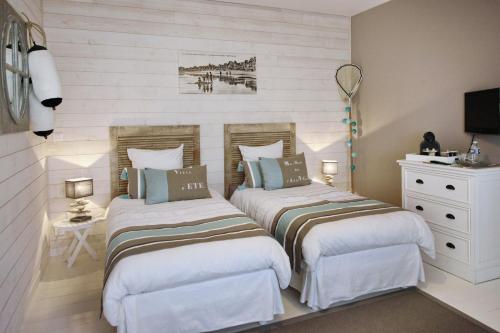 une chambre avec deux lits et une commode dans l'établissement La Maison au-dessus des Voiles, à La Baule