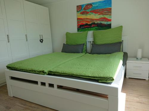 a bedroom with a bed with a green comforter at Zur alten Schmiede in Ladelund