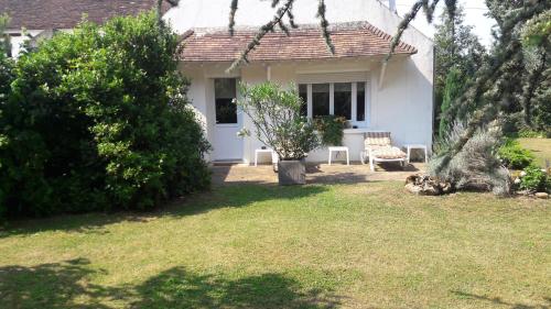 a white house with a chair in the yard at Les Ecureuils in Bougligny