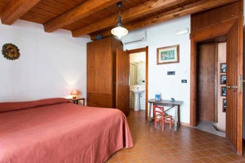 a bedroom with a red bed and a table at Le Piccole Grotte in Scilla