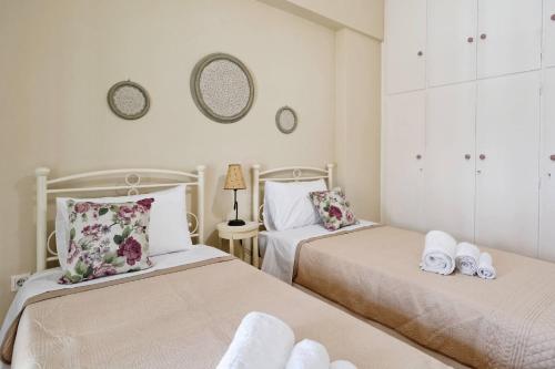 sypialnia z 2 łóżkami i ręcznikami w obiekcie Caryatis Apartment w Atenach
