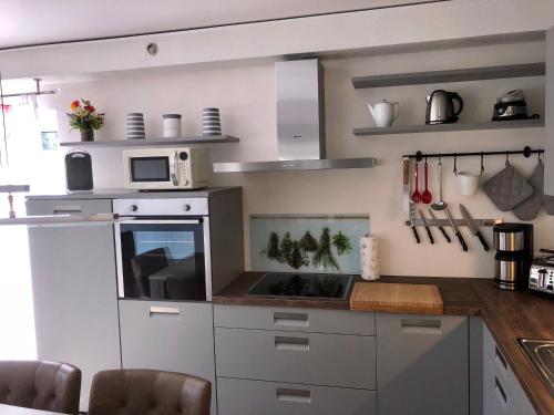 a kitchen with white cabinets and a microwave at Ferienhaus Traumspot in Wiek auf Rügen 