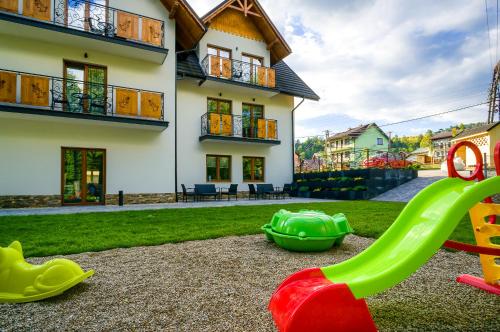 a playground in front of a house with a slide at Willa Na Skarpie in Szczawnica