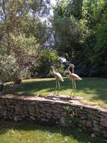 two birds standing on top of a stone wall at les alicantes in Coursan
