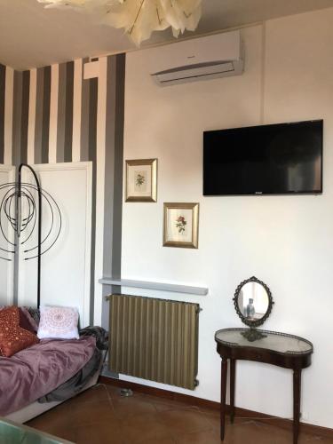 a living room with a radiator and a television on the wall at Dimora del Podestà in CastellʼArquato