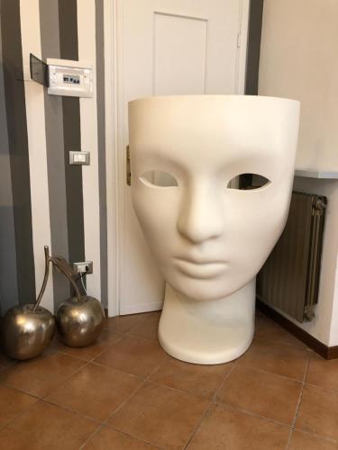 a white mask sitting in a room with two balls at Dimora del Podestà in CastellʼArquato