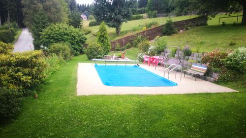 a swimming pool in a yard with a playground at Penzion U Horejšů, Zadov - Churáňov in Stachy