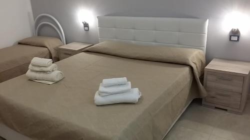 1 dormitorio con 2 camas y toallas. en CASA ARCHIMEDE, en Siracusa