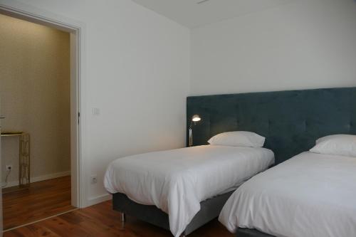A bed or beds in a room at Guest House Eça - Centro Histórico Leiria