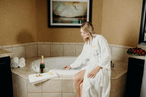 una mujer sentada en una bañera con una botella de champán en Gold Country Casino Resort, en Oroville