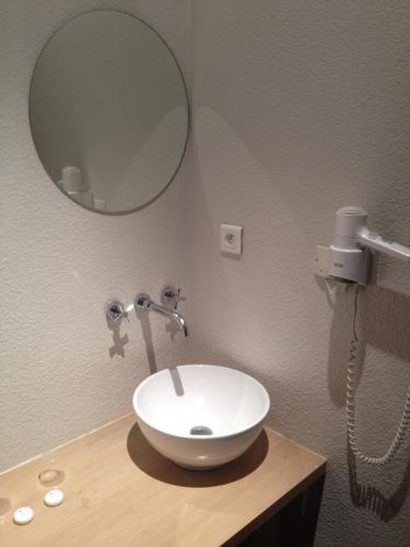une salle de bain avec un lavabo blanc et un miroir dans l'établissement Hotel Restaurant La Frégate, à La Seyne-sur-Mer