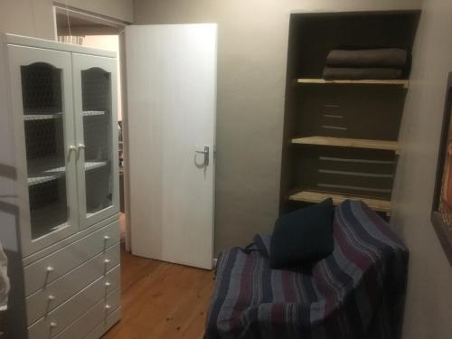 a room with a closet and a couch and a bed at Old Balgowan Farm Cottage in Balgowan