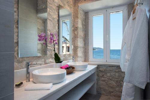 a bathroom with two sinks and a window at Villa Aelia in Kassiopi