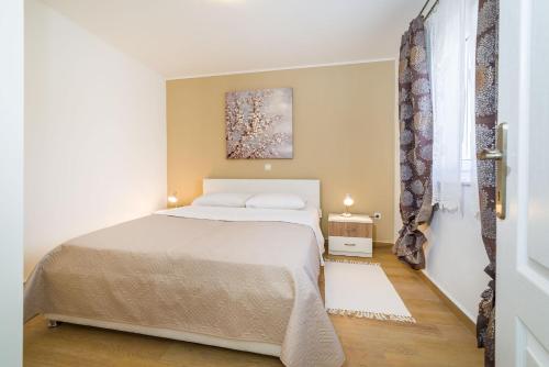 a bedroom with a bed and a painting on the wall at Long Island Olive Apartment in Sali