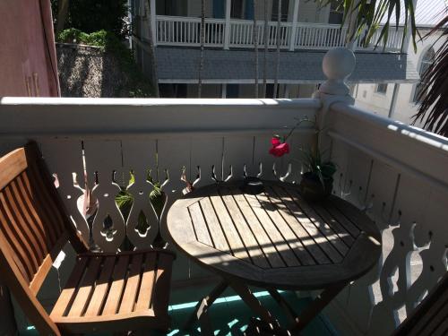a balcony with two chairs and a table and a flower at Courtney's Place Historic Cottages & Inns in Key West