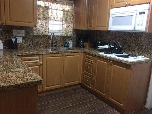 a kitchen with wooden cabinets and a sink and a stove at Courtney's Place Historic Cottages & Inns in Key West