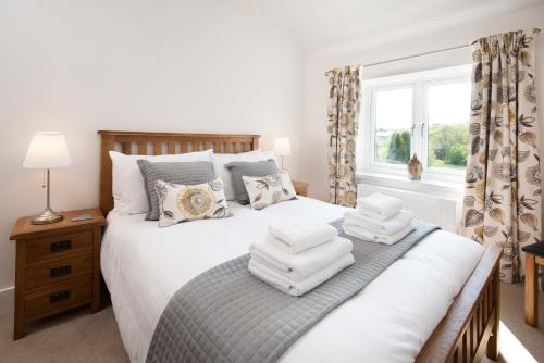 une chambre avec un lit avec des serviettes dessus dans l'établissement Lizzies Cottage, à Berwick-upon-Tweed