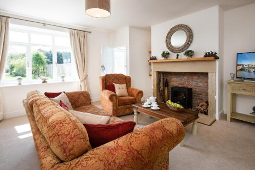 a living room with two couches and a fireplace at Lizzies Cottage in Berwick-Upon-Tweed