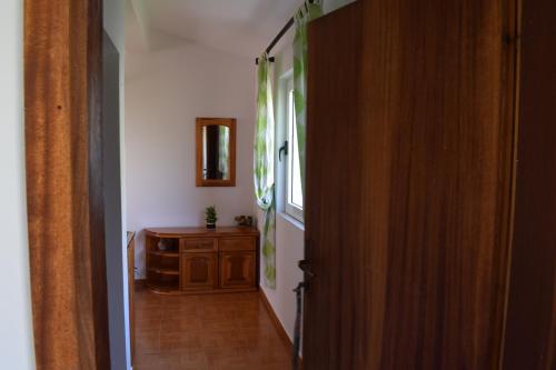 a hallway with a room with a window and a wooden door at Bisha Apartments in Ulcinj