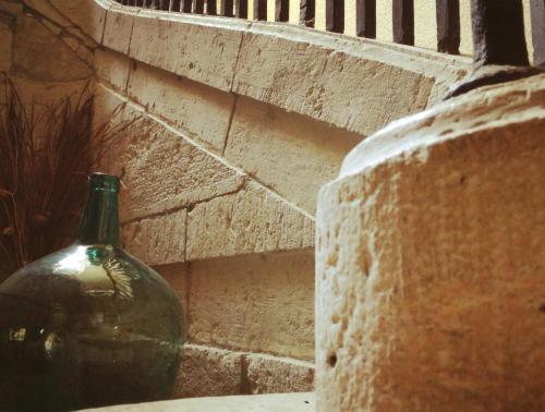 a green glass vase sitting next to a brick wall at L'Amirauté sur Baïse in Saint-Jean-Poutge