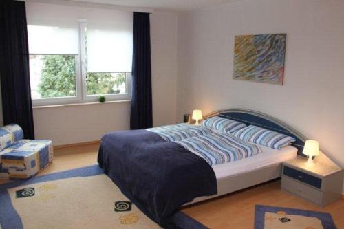 霍茲明登的住宿－Fewo Weser，一间卧室设有一张床和两个窗户。