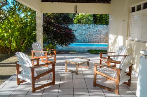 a group of chairs and a table on a patio at Casa Caiçara in São Miguel dos Milagres