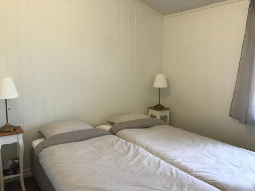 two beds in a small room with two lamps at Apartments in Svarte in Ystad