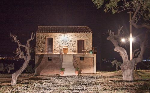 uma pequena casa de pedra à noite com uma luz de rua em La Giara B&B em San Demetrio Corone