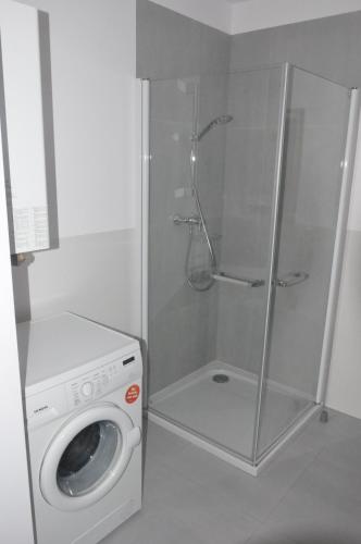 ウストロニエ・モルスキエにあるApartament HORYZONTのバスルーム(シャワー付)の洗濯機が備わります。