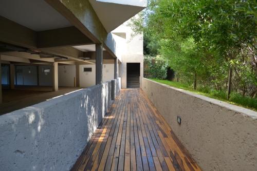 an empty walkway to a building with a wooden deck at Valeria Playa Apart in Valeria del Mar