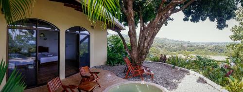 a house with two chairs and a tree at LagunaVista Villas in Carate